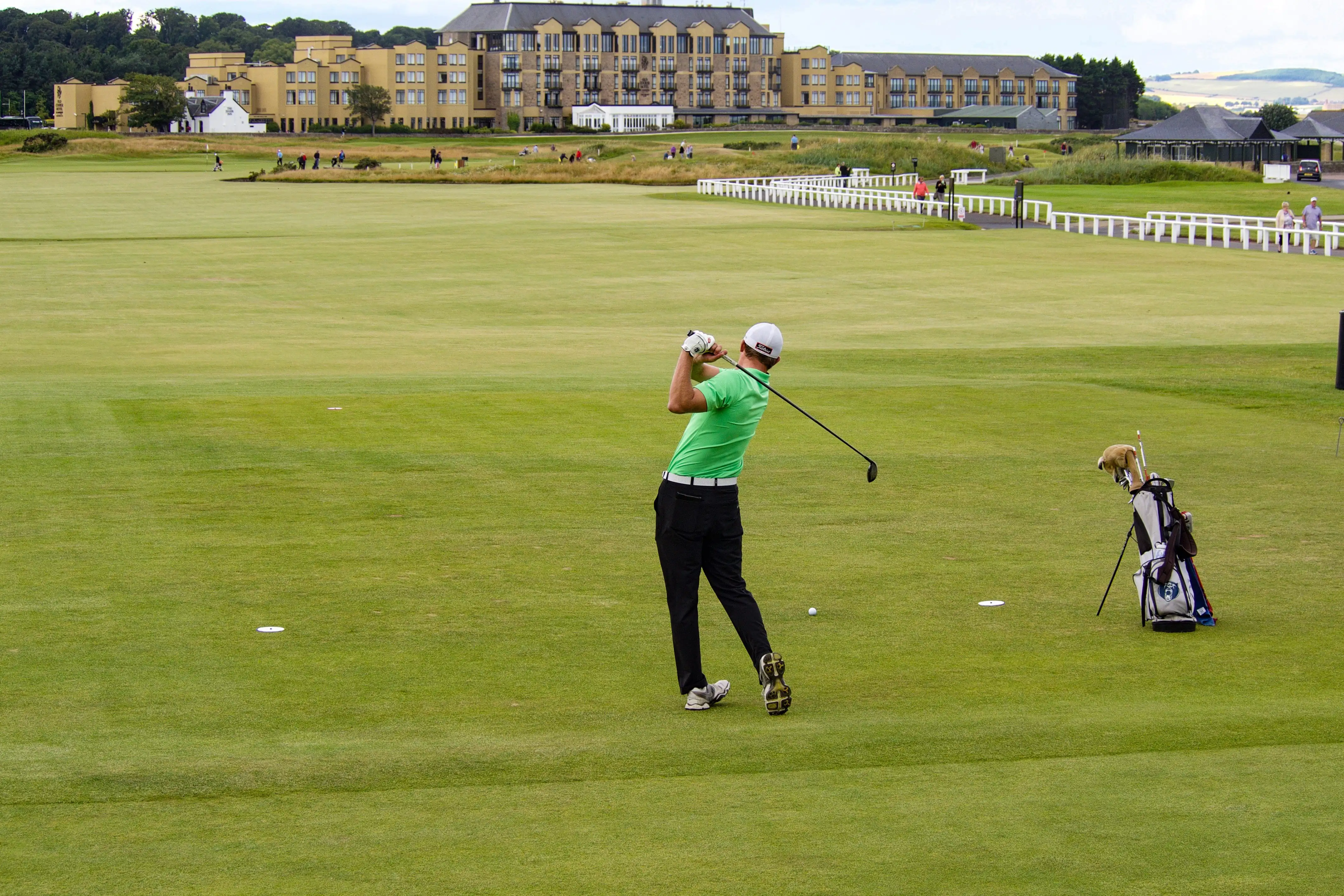 Golfer playing beside a resort on an Irish golf course