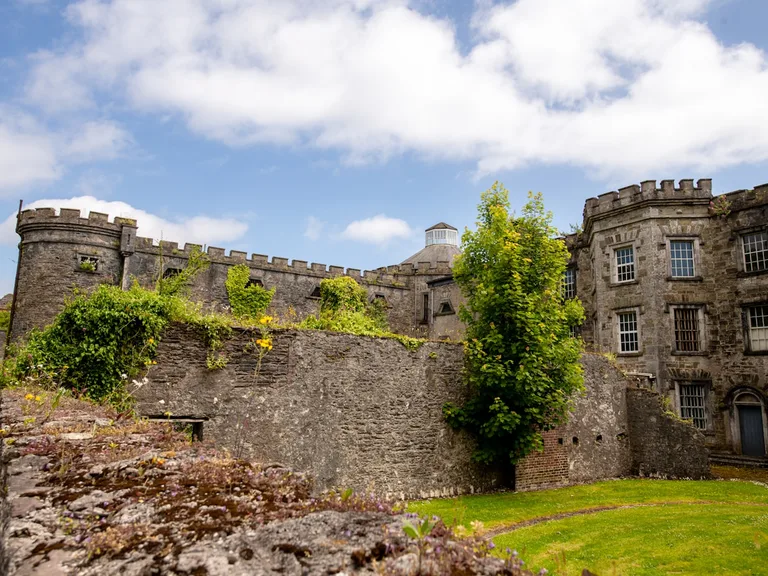Historic Cork City Gaol surrounded by green lawn
